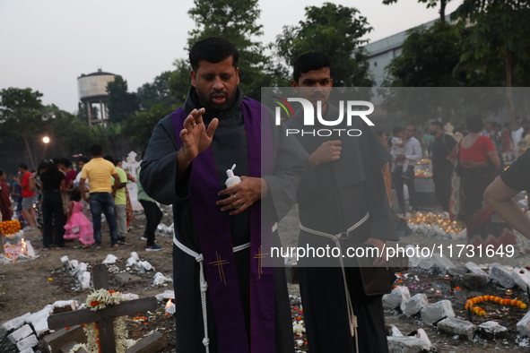 People light candles and lay flowers on the graves of their relatives at a cemetery during All Souls Day in Kolkata, India, on November 2, 2...