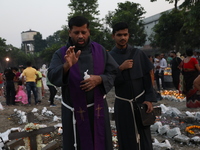 People light candles and lay flowers on the graves of their relatives at a cemetery during All Souls Day in Kolkata, India, on November 2, 2...