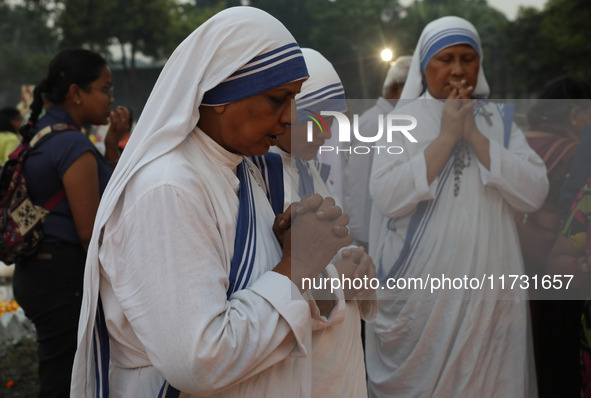 People light candles and lay flowers on the graves of their relatives at a cemetery during All Souls Day in Kolkata, India, on November 2, 2...