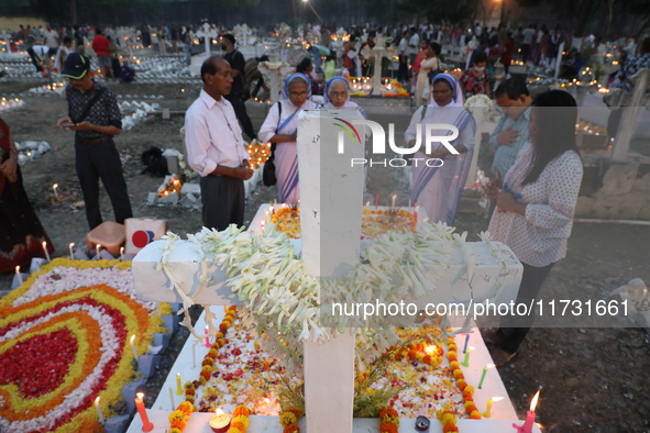 People light candles and lay flowers on the graves of their relatives at a cemetery during All Souls Day in Kolkata, India, on November 2, 2...