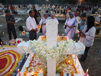 People light candles and lay flowers on the graves of their relatives at a cemetery during All Souls Day in Kolkata, India, on November 2, 2...