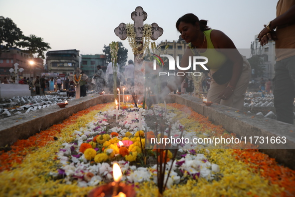 People light candles and lay flowers on the graves of their relatives at a cemetery during All Souls Day in Kolkata, India, on November 2, 2...