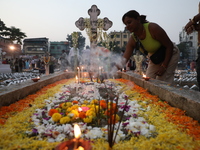 People light candles and lay flowers on the graves of their relatives at a cemetery during All Souls Day in Kolkata, India, on November 2, 2...