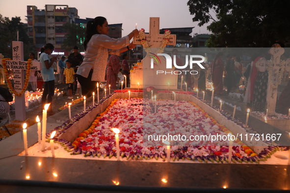 People light candles and lay flowers on the graves of their relatives at a cemetery during All Souls Day in Kolkata, India, on November 2, 2...