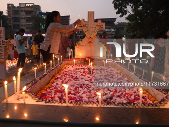 People light candles and lay flowers on the graves of their relatives at a cemetery during All Souls Day in Kolkata, India, on November 2, 2...