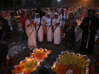 People light candles and lay flowers on the graves of their relatives at a cemetery during All Souls Day in Kolkata, India, on November 2, 2...