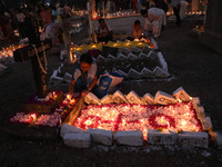 People light candles and lay flowers on the graves of their relatives at a cemetery during All Souls Day in Kolkata, India, on November 2, 2...