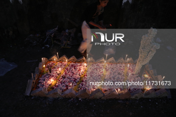 People light candles and lay flowers on the graves of their relatives at a cemetery during All Souls Day in Kolkata, India, on November 2, 2...