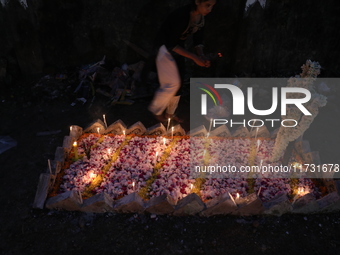 People light candles and lay flowers on the graves of their relatives at a cemetery during All Souls Day in Kolkata, India, on November 2, 2...