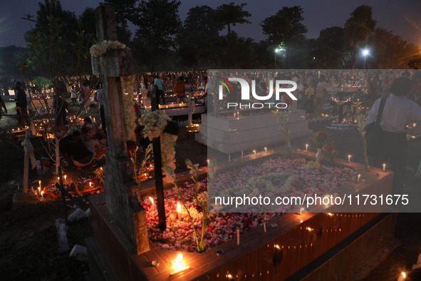 People light candles and lay flowers on the graves of their relatives at a cemetery during All Souls Day in Kolkata, India, on November 2, 2...