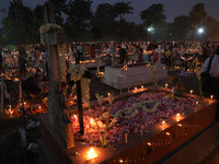 People light candles and lay flowers on the graves of their relatives at a cemetery during All Souls Day in Kolkata, India, on November 2, 2...