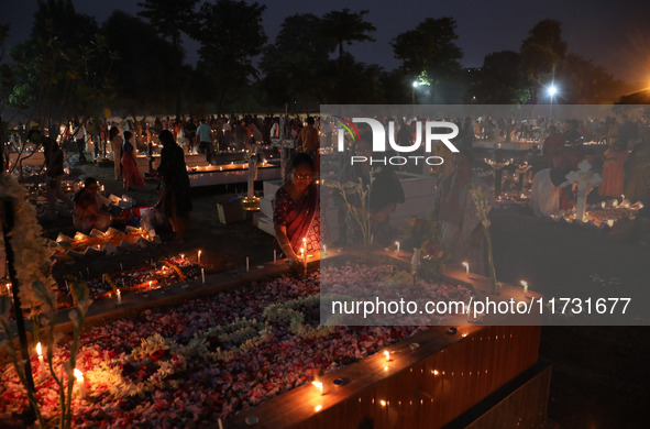 People light candles and lay flowers on the graves of their relatives at a cemetery during All Souls Day in Kolkata, India, on November 2, 2...