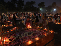 People light candles and lay flowers on the graves of their relatives at a cemetery during All Souls Day in Kolkata, India, on November 2, 2...