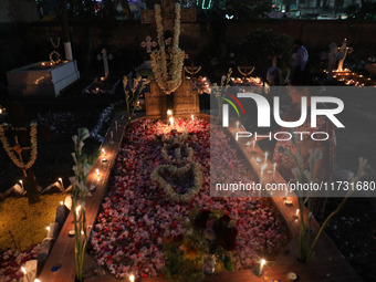 People light candles and lay flowers on the graves of their relatives at a cemetery during All Souls Day in Kolkata, India, on November 2, 2...