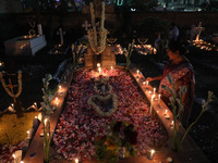 People light candles and lay flowers on the graves of their relatives at a cemetery during All Souls Day in Kolkata, India, on November 2, 2...