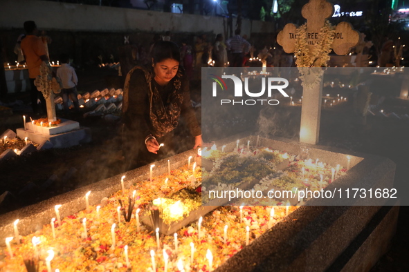 People light candles and lay flowers on the graves of their relatives at a cemetery during All Souls Day in Kolkata, India, on November 2, 2...