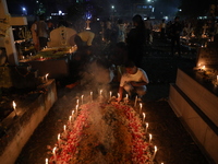 People light candles and lay flowers on the graves of their relatives at a cemetery during All Souls Day in Kolkata, India, on November 2, 2...