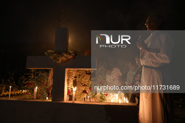 People light candles and lay flowers on the graves of their relatives at a cemetery during All Souls Day in Kolkata, India, on November 2, 2...