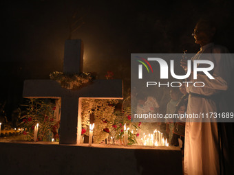 People light candles and lay flowers on the graves of their relatives at a cemetery during All Souls Day in Kolkata, India, on November 2, 2...