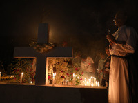 People light candles and lay flowers on the graves of their relatives at a cemetery during All Souls Day in Kolkata, India, on November 2, 2...