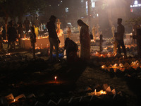 People light candles and lay flowers on the graves of their relatives at a cemetery during All Souls Day in Kolkata, India, on November 2, 2...