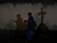 People light candles and lay flowers on the graves of their relatives at a cemetery during All Souls Day in Kolkata, India, on November 2, 2...