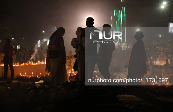 People light candles and lay flowers on the graves of their relatives at a cemetery during All Souls Day in Kolkata, India, on November 2, 2...