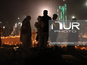 People light candles and lay flowers on the graves of their relatives at a cemetery during All Souls Day in Kolkata, India, on November 2, 2...