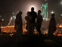 People light candles and lay flowers on the graves of their relatives at a cemetery during All Souls Day in Kolkata, India, on November 2, 2...