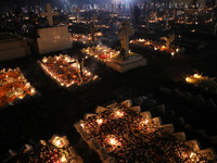 People light candles and lay flowers on the graves of their relatives at a cemetery during All Souls Day in Kolkata, India, on November 2, 2...