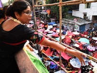 Shashi Panja, Minister of Women and Child Development and Social Welfare of West Bengal, and Indian devotees collect holy rice during the An...