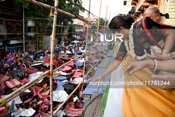 Shashi Panja, Minister of Women and Child Development and Social Welfare of West Bengal, and Indian devotees collect holy rice during the An...