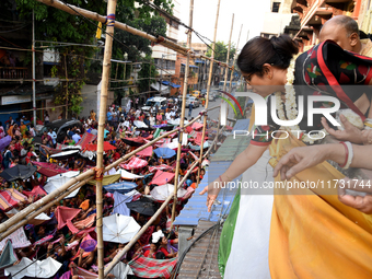 Shashi Panja, Minister of Women and Child Development and Social Welfare of West Bengal, and Indian devotees collect holy rice during the An...