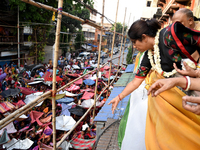 Shashi Panja, Minister of Women and Child Development and Social Welfare of West Bengal, and Indian devotees collect holy rice during the An...