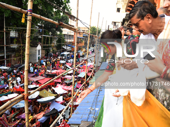 Shashi Panja, Minister of Women and Child Development and Social Welfare of West Bengal, and Indian devotees collect holy rice during the An...