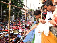 Shashi Panja, Minister of Women and Child Development and Social Welfare of West Bengal, and Indian devotees collect holy rice during the An...