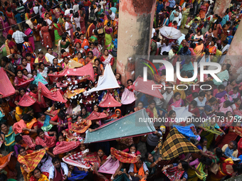 Indian devotees collect holy rice during the Annakut Utsav (Govardhan Puja) at Madan Mohon Mandir in Kolkata, India, on November 2, 2024. Pe...