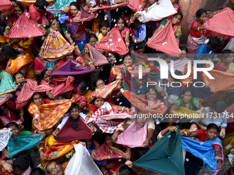 Indian devotees collect holy rice during the Annakut Utsav (Govardhan Puja) at Madan Mohon Mandir in Kolkata, India, on November 2, 2024. Pe...