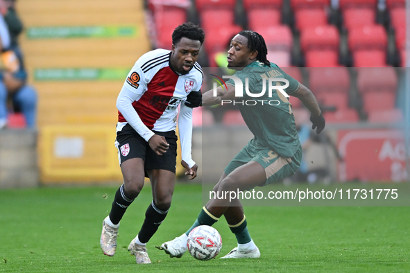 Timi Odusina (5 Woking) is challenged by Dan Nlundulu (9 Cambridge United) during the FA Cup First Round match between Woking and Cambridge...