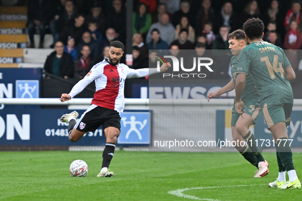 Dennon Lewis (11 Woking) shoots during the FA Cup First Round match between Woking and Cambridge United at the Kingfield Stadium in Woking,...