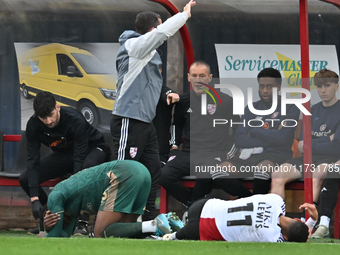 Jubril Okedina (15, Cambridge United) and Dennon Lewis (11, Woking) collide on the touchline during the FA Cup First Round match between Wok...