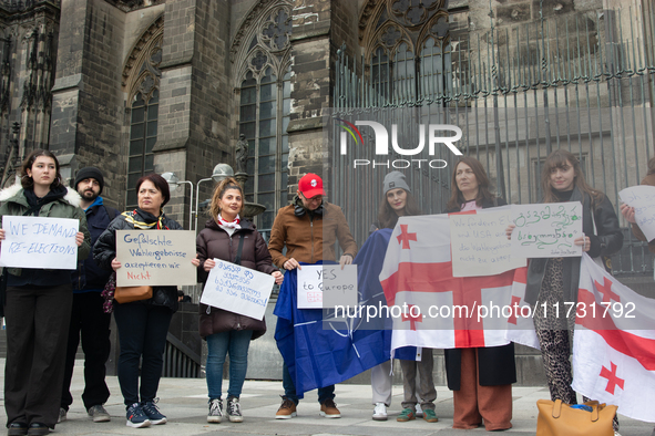 A dozen protesters gather in front of Dom Cathedral to contest the result of the Georgian election and demand a new election in Cologne, Ger...