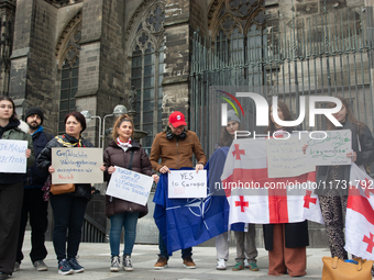 A dozen protesters gather in front of Dom Cathedral to contest the result of the Georgian election and demand a new election in Cologne, Ger...