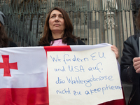 A dozen protesters gather in front of Dom Cathedral to contest the result of the Georgian election and demand a new election in Cologne, Ger...