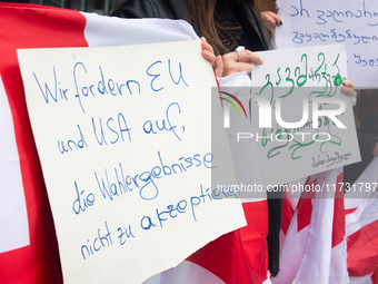 A dozen protesters gather in front of Dom Cathedral to contest the result of the Georgian election and demand a new election in Cologne, Ger...