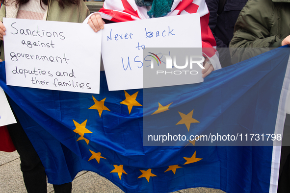 A dozen protesters gather in front of Dom Cathedral to contest the result of the Georgian election and demand a new election in Cologne, Ger...