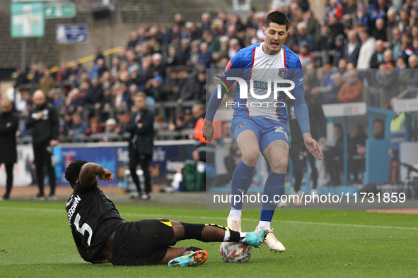 Steven Sessegnon of Wigan Athletic challenges Jon Mellish of Carlisle United during the FA Cup First Round match between Carlisle United and...