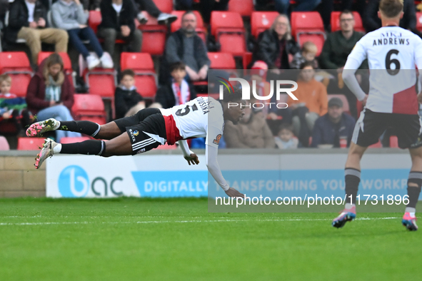 Timi Odusina (5 Woking) is in action during the FA Cup First Round match between Woking and Cambridge United at the Kingfield Stadium in Wok...