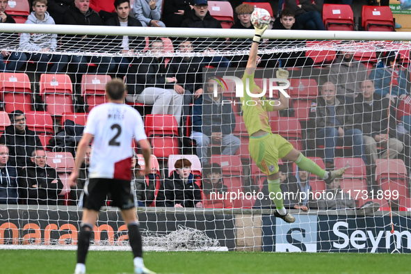 Goalkeeper Will Jaaskelainen, from Woking, tips the ball over late during the FA Cup First Round match between Woking and Cambridge United a...