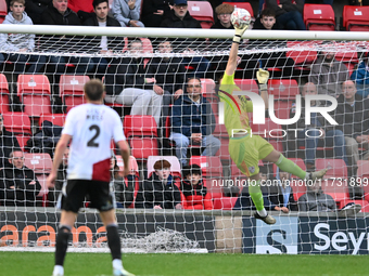 Goalkeeper Will Jaaskelainen, from Woking, tips the ball over late during the FA Cup First Round match between Woking and Cambridge United a...